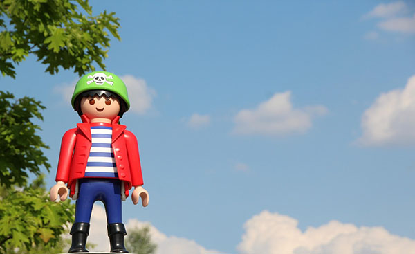 Playmobil con casco verde y chaqueta roja fotografiado al aire libre